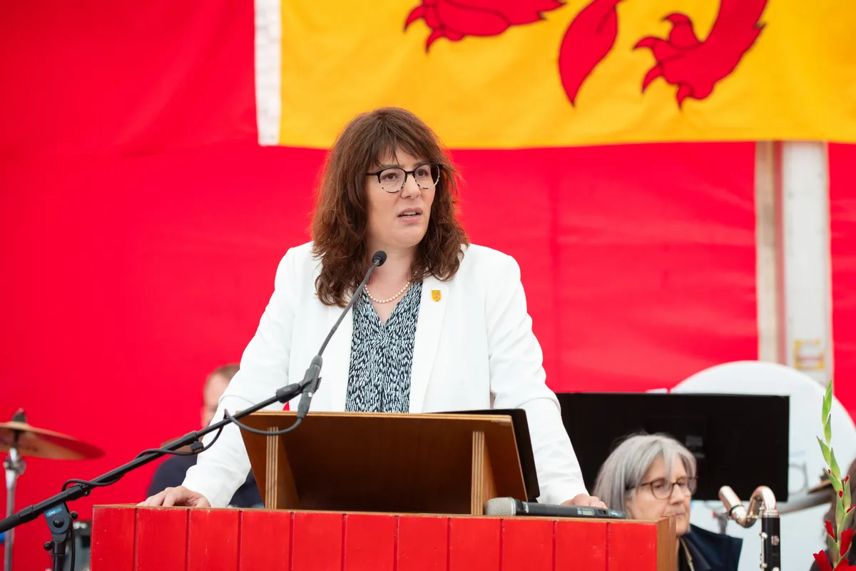 Mehr bürgerlich-liberal, weniger grün: Gemeindepräsidentin Monika Keller (FDP) will Greifensee dennoch als naturfreundliche Gemeinde weiterführen. Monika Keller am Podium, sie kündigt die 1. August-Rede an.